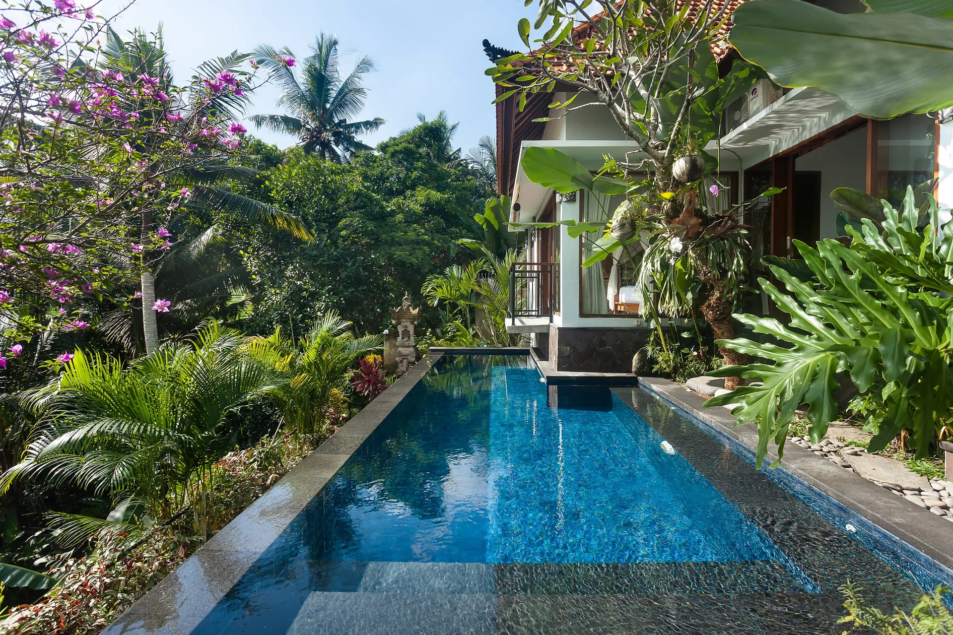 Long blue-tiled pool beside a tropical garden and villa terrace, 2-Bedroom Tranquility Villa at The Shea Ubud